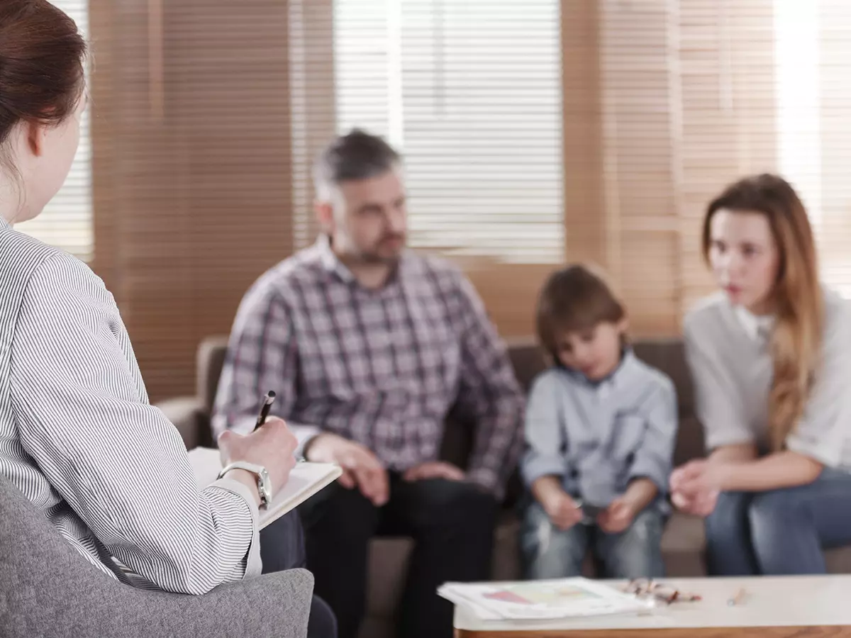 Family counseling with parents sitting on the couch